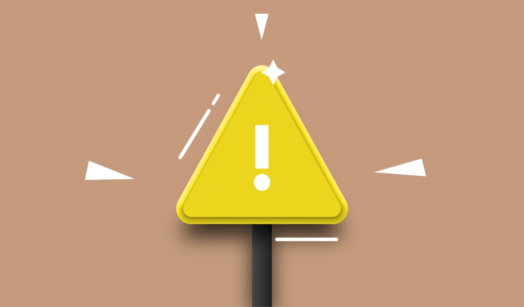 A yellow warning triangle with exclamation mark on a brown background.
